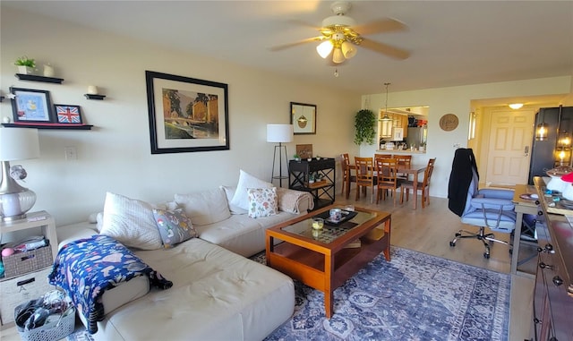 living area with wood finished floors and a ceiling fan