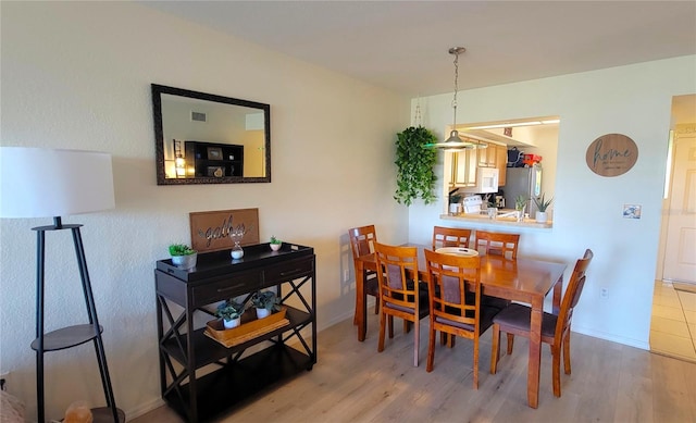dining room with wood finished floors, visible vents, and baseboards