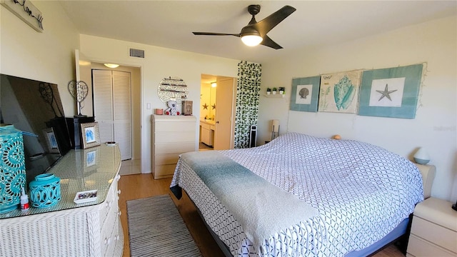 bedroom featuring light wood-style flooring, visible vents, and a ceiling fan