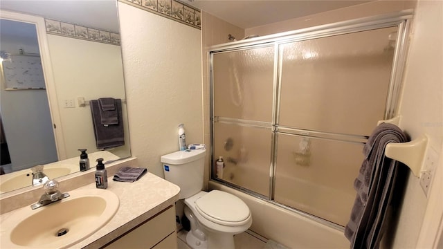 bathroom with vanity, toilet, and bath / shower combo with glass door