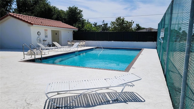 pool featuring fence and a patio area