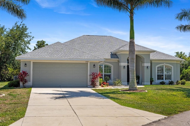 27147 Guapore Dr, Punta Gorda, FL 33983 - ranch-style house featuring driveway, an attached garage, a front yard, stucco siding, and roof with shingles