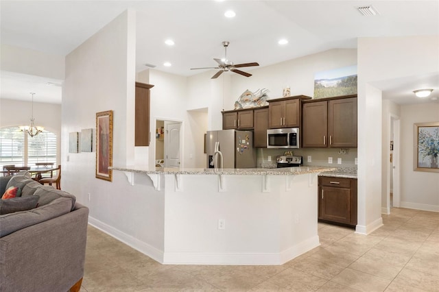 27147 Guapore Dr, Punta Gorda, FL 33983 - kitchen with ceiling fan with notable chandelier, a kitchen bar, a peninsula, appliances with stainless steel finishes, and visible vents