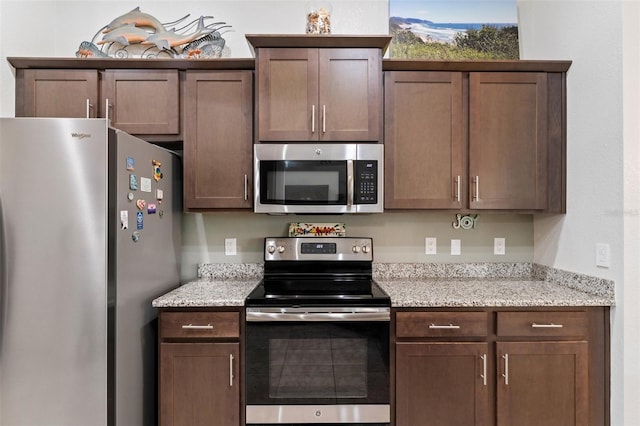 27147 Guapore Dr, Punta Gorda, FL 33983 - kitchen with light stone counters, dark brown cabinetry, and appliances with stainless steel finishes