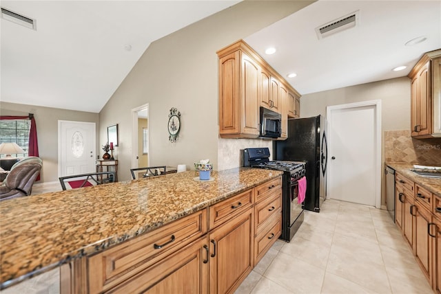 kitchen featuring decorative backsplash, visible vents, light stone counters, and black appliances