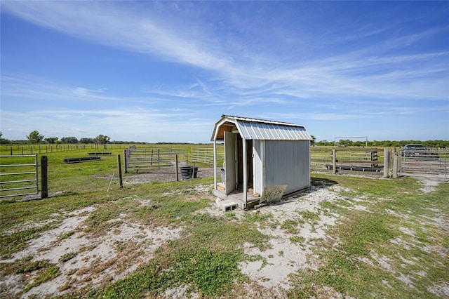 view of shed with fence and a rural view