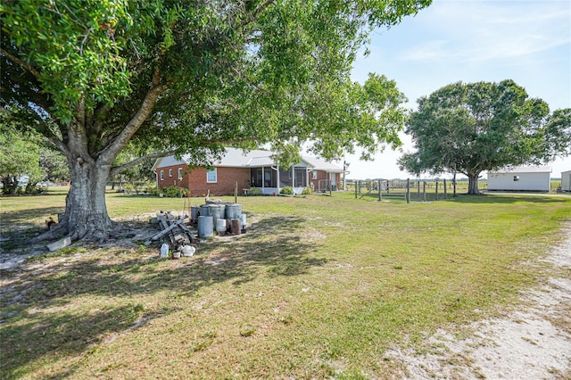 view of yard featuring a sunroom and fence