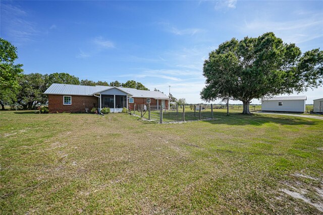 view of yard with fence and a sunroom