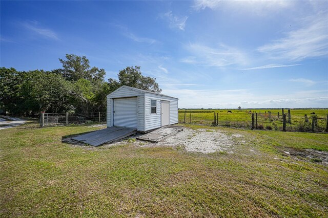 view of shed with fence and a rural view