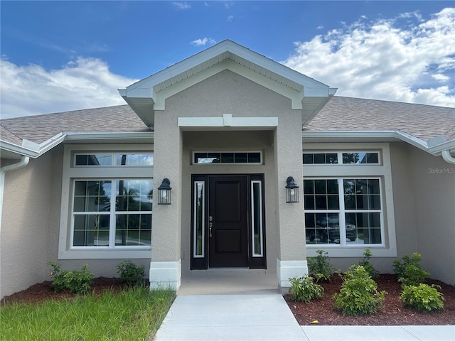 23245 Jules Ave, Port Charlotte, FL 33980 - property entrance featuring stucco siding and a shingled roof