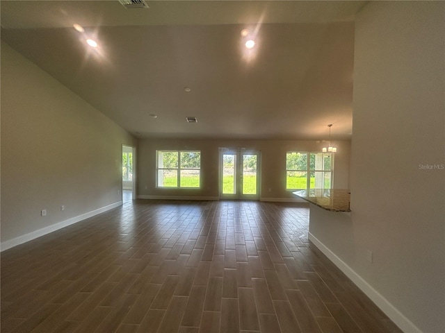 23245 Jules Ave, Port Charlotte, FL 33980 - unfurnished room featuring plenty of natural light, dark wood-style flooring, a chandelier, and lofted ceiling