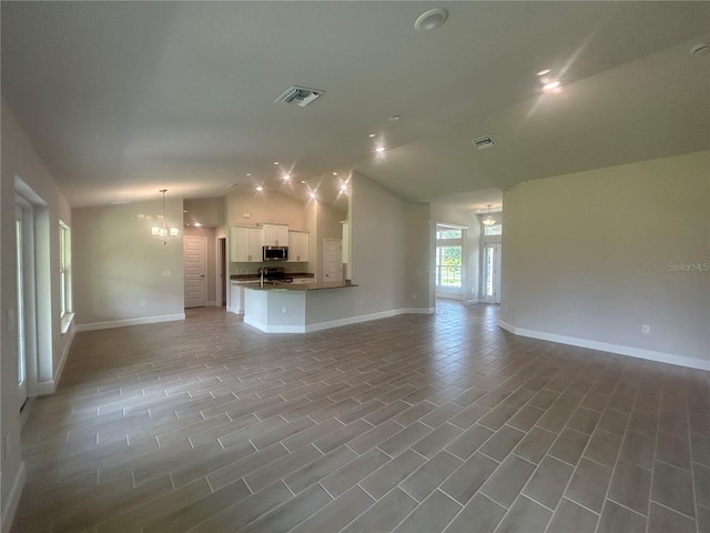 23245 Jules Ave, Port Charlotte, FL 33980 - unfurnished living room with vaulted ceiling and a chandelier