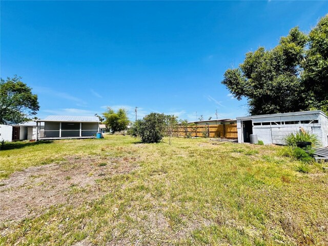 view of yard with fence and a sunroom