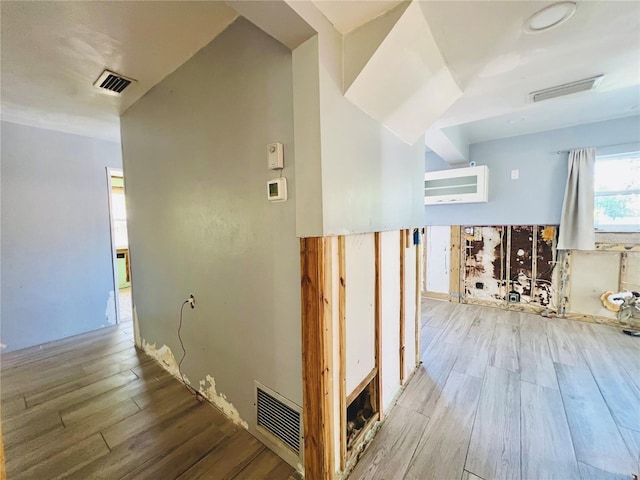 hallway featuring wood finished floors and visible vents