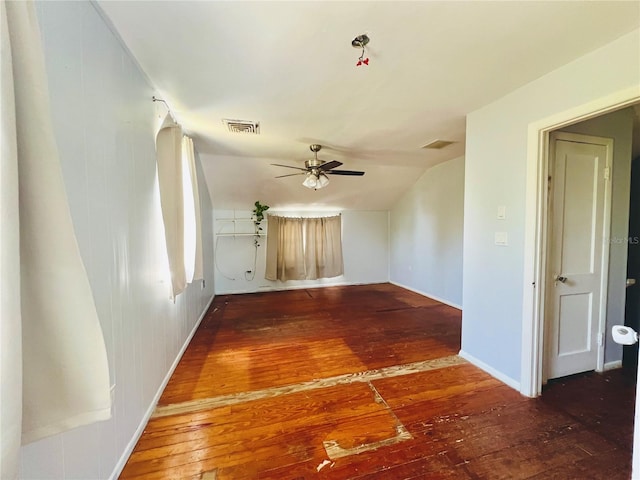 unfurnished room featuring vaulted ceiling, baseboards, visible vents, a ceiling fan, and hardwood / wood-style flooring