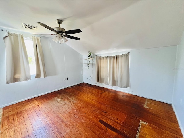 interior space with lofted ceiling, visible vents, a ceiling fan, baseboards, and hardwood / wood-style flooring
