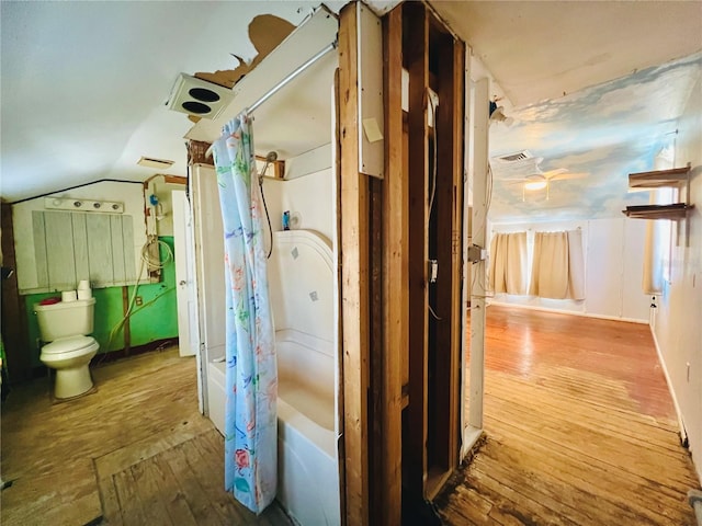 hall with lofted ceiling, baseboards, visible vents, and wood-type flooring