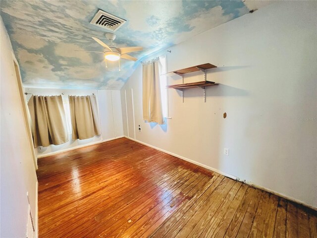 additional living space with lofted ceiling, a ceiling fan, visible vents, and hardwood / wood-style floors