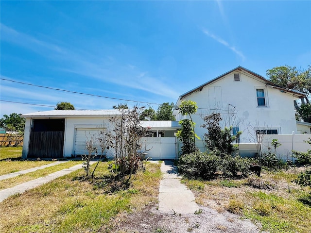 view of front of property featuring stucco siding and fence