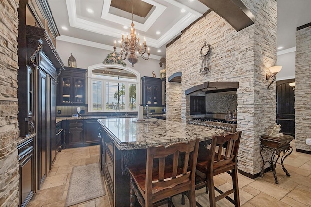 3866 Turtle Dove Blvd, Punta Gorda, FL 33950 - kitchen with stone tile flooring, light stone countertops, a towering ceiling, a kitchen island, and decorative light fixtures