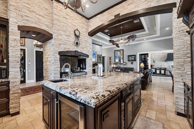 3866 Turtle Dove Blvd, Punta Gorda, FL 33950 - kitchen with open floor plan, a sink, wine cooler, stone tile flooring, and ornamental molding