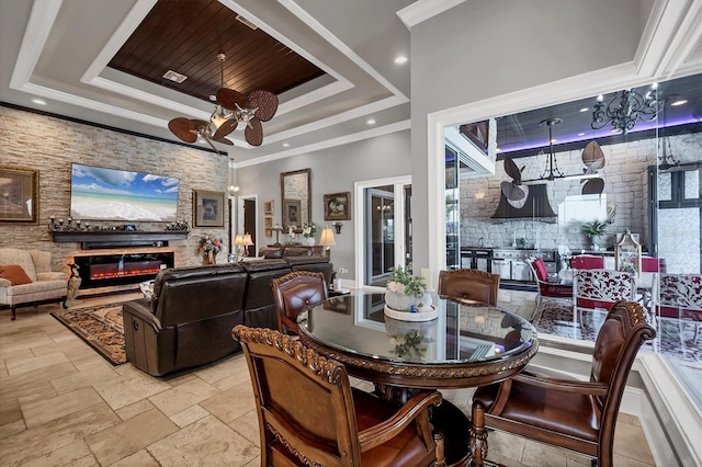 3866 Turtle Dove Blvd, Punta Gorda, FL 33950 - dining room featuring a raised ceiling, a stone fireplace, ornamental molding, stone tile flooring, and ceiling fan