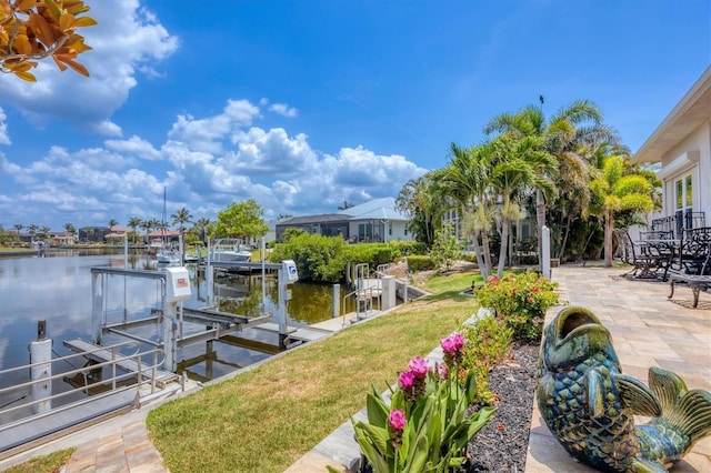 3866 Turtle Dove Blvd, Punta Gorda, FL 33950 - dock area with boat lift, a water view, a yard, and a patio