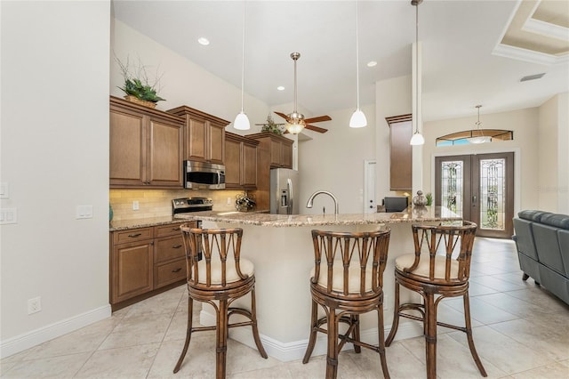 4015 La Costa Island Ct, Punta Gorda, FL 33950 - kitchen featuring appliances with stainless steel finishes, a breakfast bar, ceiling fan, and brown cabinetry