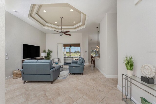 4015 La Costa Island Ct, Punta Gorda, FL 33950 - living room featuring a tray ceiling, a ceiling fan, recessed lighting, crown molding, and baseboards