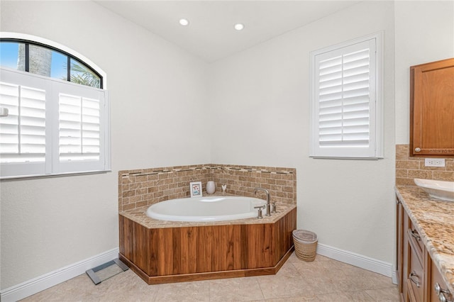 4015 La Costa Island Ct, Punta Gorda, FL 33950 - bathroom with vanity, a garden tub, baseboards, and decorative backsplash