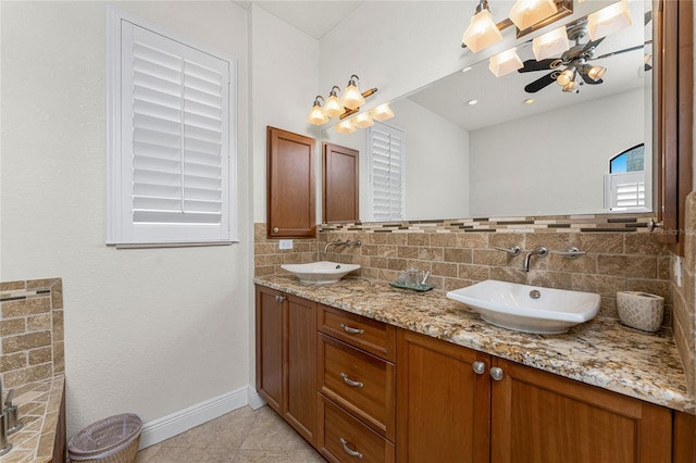 4015 La Costa Island Ct, Punta Gorda, FL 33950 - full bathroom with double vanity, tile patterned floors, baseboards, a ceiling fan, and tasteful backsplash
