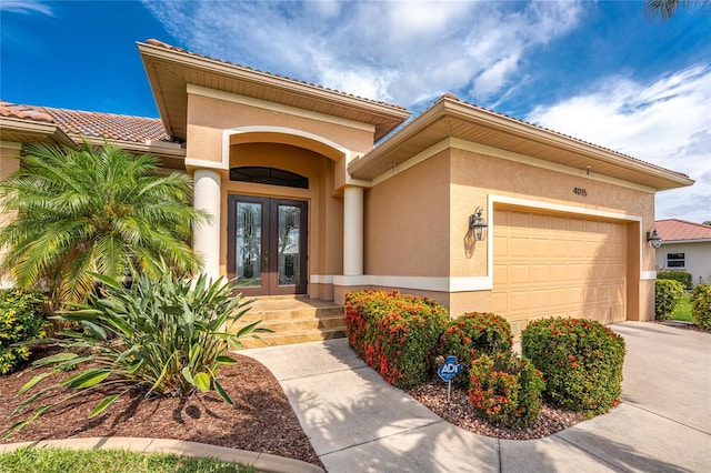 4015 La Costa Island Ct, Punta Gorda, FL 33950 - property entrance featuring french doors, stucco siding, driveway, an attached garage, and a tile roof