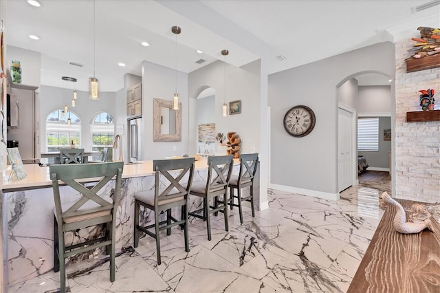 303 11th Ave E, Palmetto, FL 34221 - dining room featuring arched walkways, plenty of natural light, light marble finish flooring, recessed lighting, and baseboards