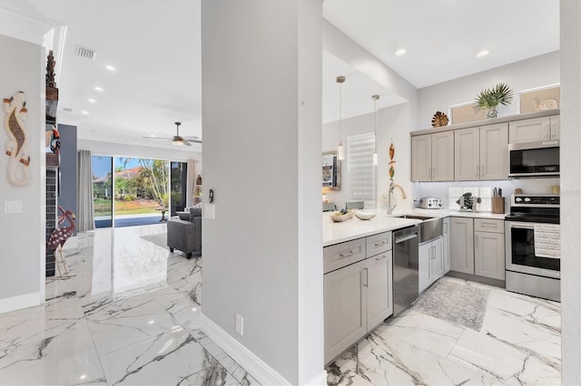 303 11th Ave E, Palmetto, FL 34221 - kitchen with stainless steel appliances, light marble finish floors, a sink, gray cabinets, and recessed lighting