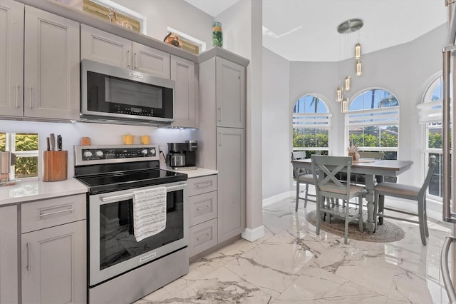 303 11th Ave E, Palmetto, FL 34221 - kitchen with appliances with stainless steel finishes, light marble finish floors, gray cabinetry, light countertops, and baseboards
