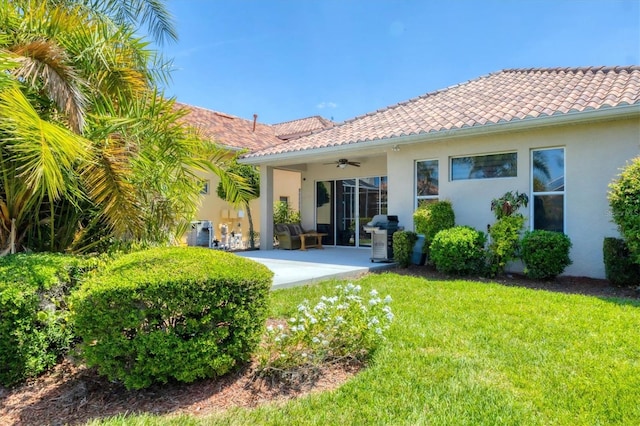 303 11th Ave E, Palmetto, FL 34221 - back of property with ceiling fan, stucco siding, a lawn, and a patio