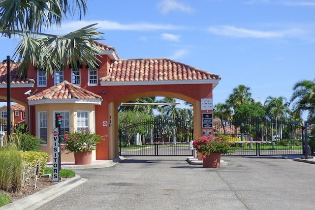 303 11th Ave E, Palmetto, FL 34221 - view of asphalt street with a gate, curbs, and a gated entry