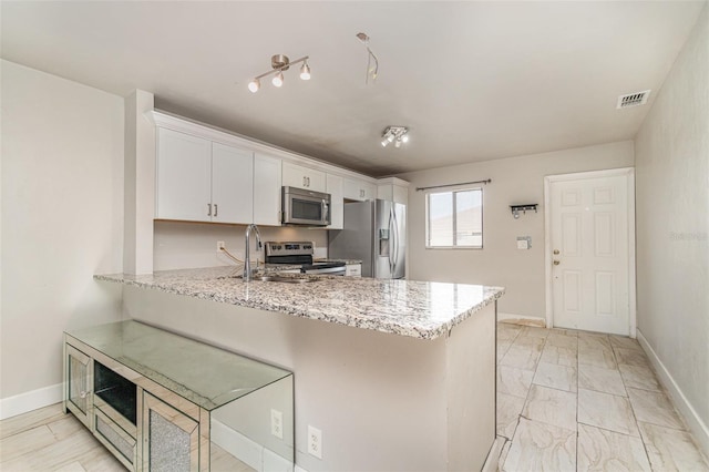 4516 Santa Barbara Blvd Unit 1, Cape Coral, FL 33914 - kitchen featuring a sink, baseboards, a peninsula, appliances with stainless steel finishes, and white cabinetry