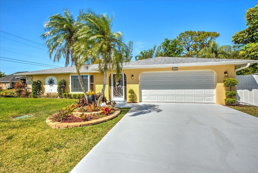 ranch-style home with concrete driveway, an attached garage, fence, a front yard, and stucco siding