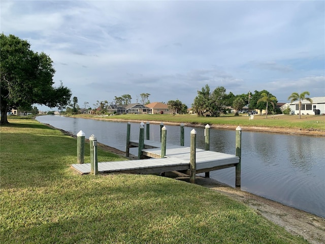 dock area featuring a residential view, a lawn, and a water view