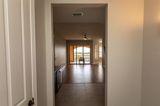 hall featuring visible vents, tile patterned flooring, and baseboards
