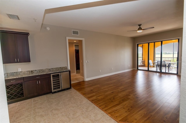 interior space with light wood-style floors, visible vents, ceiling fan, and wine cooler