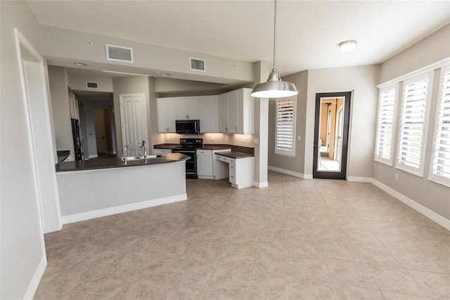 kitchen with dark countertops, black appliances, and visible vents