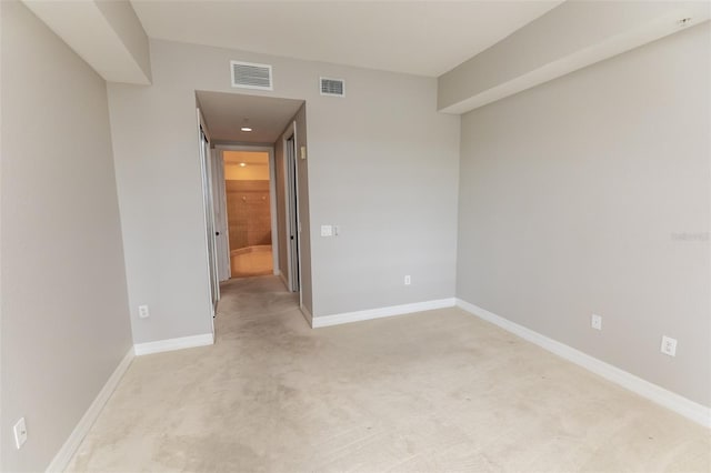 unfurnished room featuring light carpet, baseboards, and visible vents
