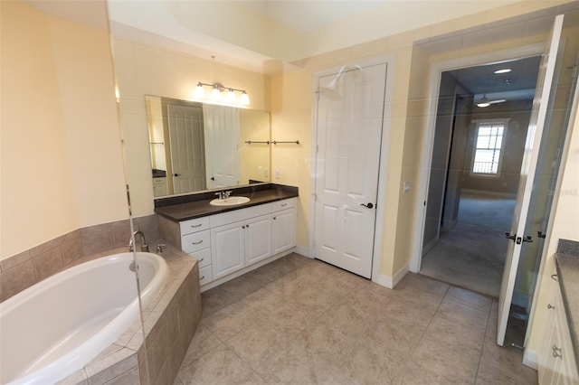 full bathroom featuring tile patterned floors, a garden tub, and vanity
