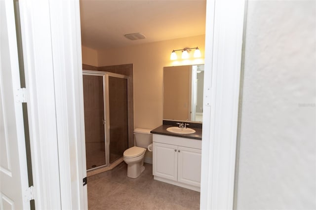 bathroom featuring toilet, vanity, visible vents, tile patterned floors, and a stall shower
