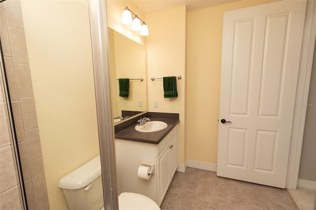 bathroom featuring vanity, toilet, baseboards, and tile patterned flooring