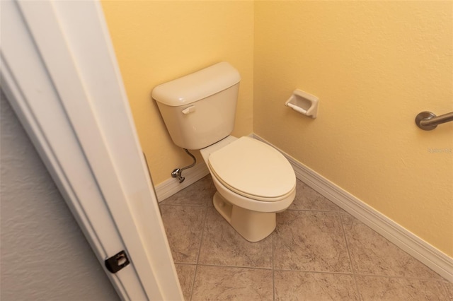bathroom with tile patterned flooring, toilet, and baseboards