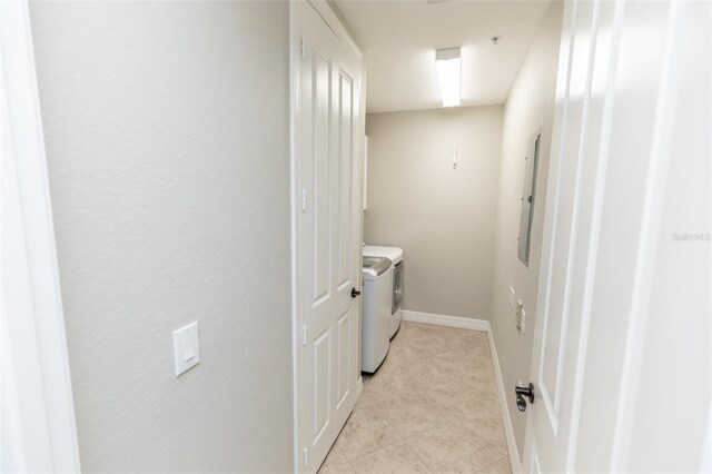 laundry room featuring separate washer and dryer, laundry area, light tile patterned floors, and electric panel