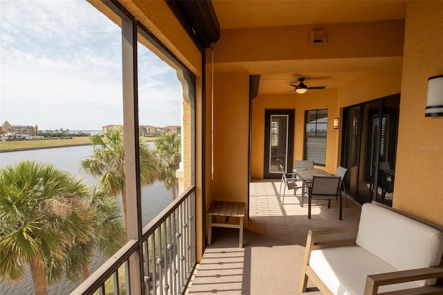 balcony featuring a water view and ceiling fan